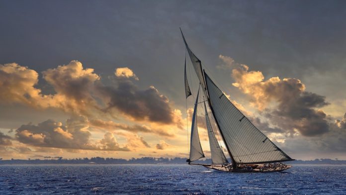 Classic,Sailboat,Sailing,At,Sunset,With,Clouds